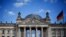 FILE - A German flag flutters in front of the Reichstag building in Berlin, Germany, Sept. 6, 2020. The inscription on the building reads "[Dedicated] to the German people."