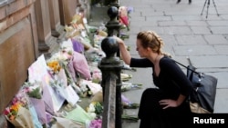 一名女士在美国流行歌手阿里安娜·格兰德的音乐会门口哀悼(2017年5月23日)