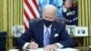 U.S. President Joe Biden signs executive orders in the Oval Office of the White House in Washington, after his inauguration as the 46th President of the United States, January 20, 2021.