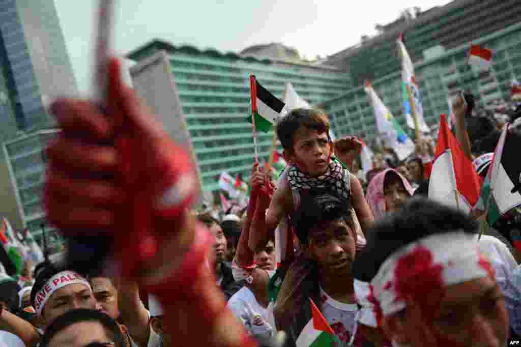 Demonstran di Indonesia, beberapa memerciki wajahnya dengan cat merah, melakukan unjuk rasa besar-besaran di Jakarta mendukung Palestina dan mengutuk serangan Israel di Gaza. &nbsp;