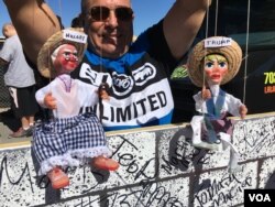 A man holds puppets representing Donald Trump and Hillary Clinton in Las Vegas, Nevada, a few kilometers from the site of the third presidential debate, Oct. 19, 2016. (J. Oni/VOA)