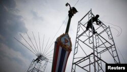 Workers prepare lighting and sound stands for a rally by pro-government "red shirt" supporters in Nakorn Pathorn province, west of Bangkok, April 4, 2014.