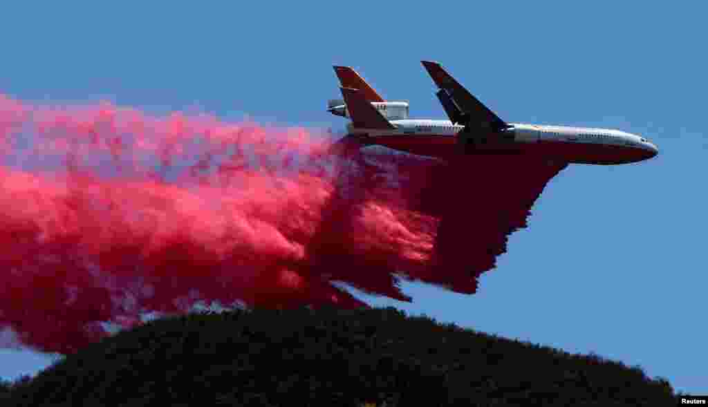 Pesawat pemadam kebakaran AS, DC-10 berusaha memadamkan kebakaran hutan yang melanda kawasan dekat kota Los Angeles, California.