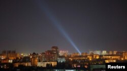 ເຈົ້າ​ໜ້າ​ທີ່​ທະ​ຫານ ຢູ​ເຄ​ຣນ ໃຊ້​ແສງ​ໄຟ​ໃນ​ຂະ​ນະ​ທີ່​ເຂົາ​ເຈົ້າ​ຊອກ​ຫາ​ໂດ​ຣນ​ເທິງ​ທ້ອງ​ຟ້າ ໃນ​ລະ​ຫວ່ງ​ການ​ໂຈມ​ຕີ​ດ້ວຍ​ໂດ​ຣນ​ຂອງ ຣັດ​ເຊຍ, 9 ກັນ​ຍາ 2024.REUTERS/Gleb Garanich