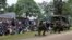 Kenyan police officers hold their position as residents watch during an operation against a gunman at the Kapenguria police station in Kapenguria, western Kenya, July 14, 2016. 