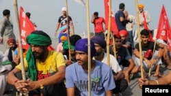 Farmers block railway tracks as part of protests against farm laws during nationwide protests, in Sonipat, northern state of Haryana, India, Sept. 27, 2021. 