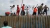 Demonstrators climb on a container they moved to use as a barricade in the Cibitoke neighborhood of Bujumbura, Burundi, May 19, 2015.