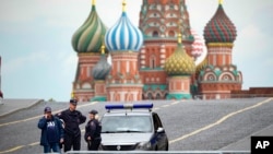 Policajci stoje pored svog automobila na praznom Crvenom trgu sa katedralom Vasilija Vasilija u pozadini, Moskva, Rusija, 28. juna 2023.