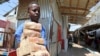 A dealer carries bundles of the Somalian currency at an open air currency exchange within the Hamarweyne open air market in Mogadishu, Somalia, Feb. 5, 2020. The World Bank and IMF have announced that Somalia is eligible for debt relief.