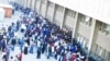 Zimbabweans gather and queue outside a Home Affairs Department office in South Africa to apply for new residence permits