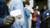 Un homme montre sa carte d'électeur à l'extérieur d'un bureau de vote dans la capitale Yaoundé, le 11 octobre 2004.