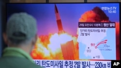 A man watches a TV screen showing a file image of North Korea's missile launch during a news program at the Seoul Railway Station in Seoul, South Korea, Sunday, March 29, 2020. 