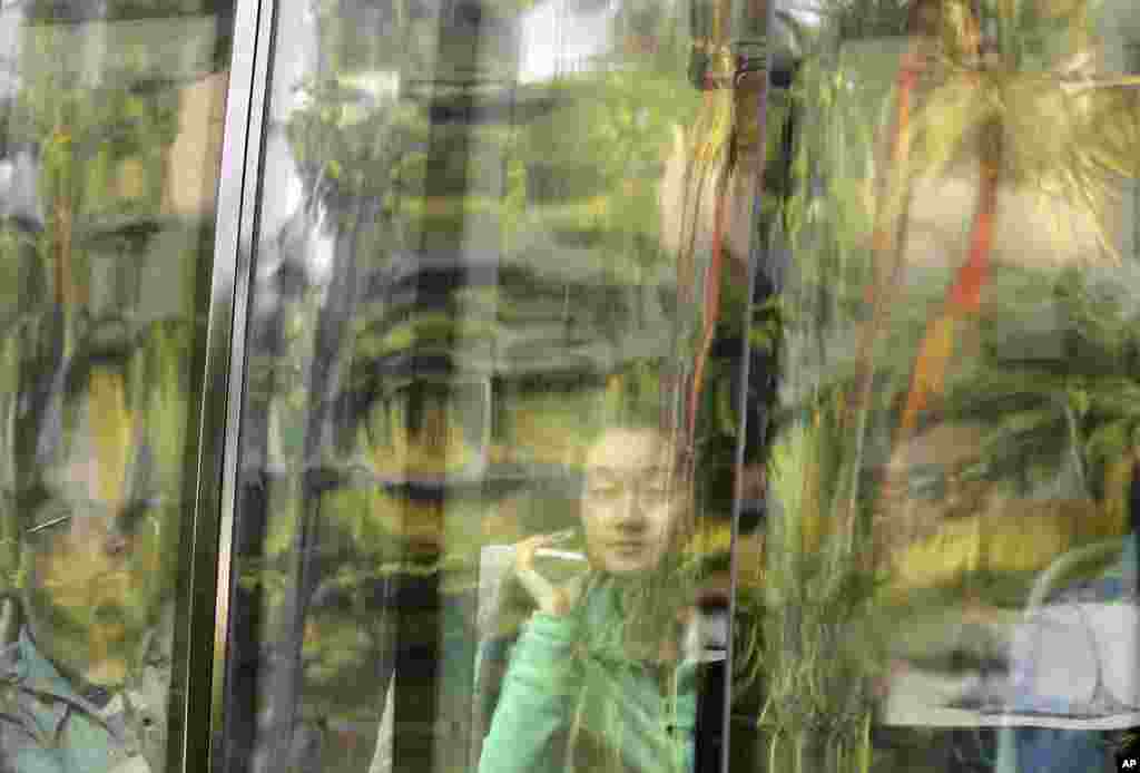 Keluarga penumpang pesawat MH370 Malaysia Airlines asal China yang masih hilang, melihat dari dalam bus saat tiba di sebuah hotel di Subang Jaya, Malaysia.