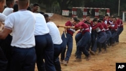 FILE - Indian army women recruits compete with men in a tug-of-war as part of their training before they are inducted as the first women soldiers below officer rank, during a media visit in Bengaluru, India.