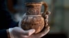 Jihad Abu Kahrlah, an archeologist at Syria's National Museum, holds an artifact delivered from the Daraa Museum to Damascus, Syria, Feb. 23, 2016. Faced with the Islamic State group onslaught and destruction by looters, Syrian antiquities authorities succeeded in evacuating hundreds of thousands of artifacts from museums around the country to safety in Damascus. 