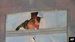 Припадник на специјалните полициски сили фрла поглед од оклопно возило во Куманово