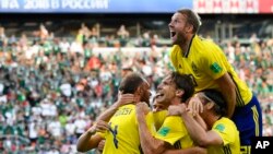 El sueco Andreas Granqvist, (izquierda) celebra con sus compañeros después de anotar el segundo gol de su equipo en el Grupo F del Mundial de Rusia en el Yekaterinburg Arena, en Ekaterimburgo, Rusia, el miércoles, 27 de junio de 2018.