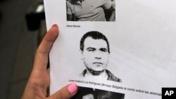 FILE- A reporter holds a picture of Antonio "Jaime" Stiusso, one of the country's most enigmatic spy chiefs, outside the prosecutor's office in Buenos Aires, Feb. 5, 2015. 