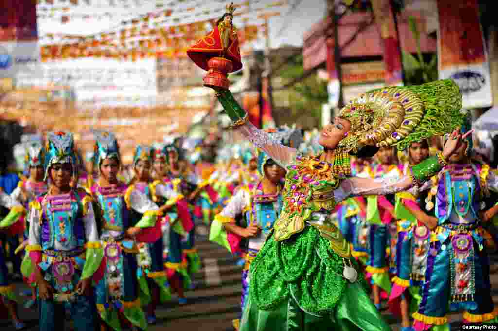Para peserta dengan mengenakan kostum yang &#39;menyala&#39; berpartisipasi dalam parade di Kota Cebu, Filipina, untuk merayakan Sinulog, festival tahunan untuk memperingati penerimaan agama Katolik Roma oleh penduduk asli di Cebu.