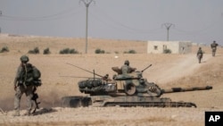 Turkish tanks and troops stationed near Syrian town of Manbij, Syria, Oct. 15, 2019. Russia moved to fill the void left by the United States in northern Syria on Tuesday, deploying troops to keep apart advancing Syrian government and Turkish forces.