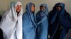 Male Afghan women's rights activists pose for media as they wear burqas to show their solidarity to Afghan women ahead of International Women's Day in Kabul, March 5, 2015. 