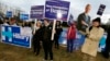 FILE - Supporters for Hillary Clinton, Bernie Sanders and Martin O’Malley rally outside the Dec. 19 Democratic presidential debate in Manchester, N.H.