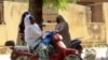 FILE - Women chatting while sitting on their bikes in a district of Maroua, northern Cameroon.