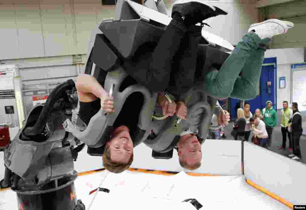 Dua orang pengunjung menikmati salah satu kendaraan robot, pada pameran robot industri di Messe Hanover di Hanover, Jerman yang berlangsung dari tanggal 8-12 April. 