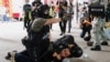 A police officer raises his pepper spray handgun as he detains a man during a march against the national security law at the anniversary of Hong Kong's handover to China from Britain in Hong Kong, July 1, 2020.