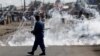 FILE - A policeman walks away after throwing a teargas canister during a protest against Burundi President Pierre Nkurunziza and his bid for a third term in Bujumbura, Burundi, June 2, 2015.