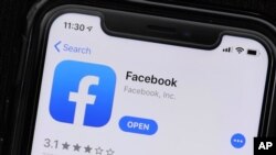 FILE - The Facebook application is displayed on a mobile phone at a store in Chicago, July 30, 2019.