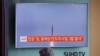 乘坐韩国首尔火车的乘客正在观看朝鲜向日本海发射三枚弹道导弹的新闻(2016年9月5日)