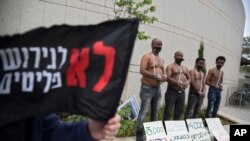 African migrants wear chains to represent slavery during a demonstration in Tel Aviv, Israel, April 3, 2018. 
