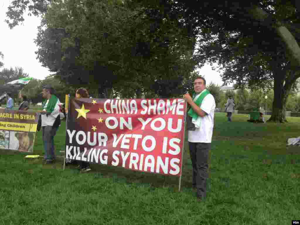 抗议人士展示谴责中国否决联合国决议的标语。