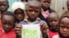 Children pose for a photo at the Bethel Outreach Children's Center in the Nairobi slum of Kibera as one boy holds up his Peepoo toilet, April 4, 2012. Toilet facilities are in poor condition or nonexistent in the slums, and safety concerns make using a to