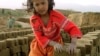 FILE - An Afghan girl makes a pile of unbaked bricks near the road passing through the Shamali Plains, about 10 kilometers ( 6 miles), west of Bagram, Afghanistan.