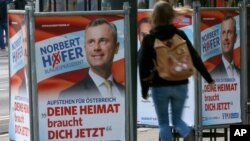 A woman walks past election posters of Norbert Hofer, candidate for presidential elections of Austria's right-wing Freedom Party, FPOe, in Vienna, Austria, April 19, 2016. The posters read "Your country needs you now."