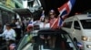 Thai anti-government protesters wave national flags as they follow march through streets of Bangkok, Dec. 20, 2013.