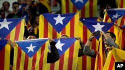 FILE - F.C Barcelona supporters wave Estelada or pro-independence flags. Catalonian lawmakers are due to vote on a measure to begin a secession process on Monday.