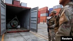 Polisi Panama menjaga kontainer yang berisi senjata yang disita dari kapal berbendera Korea Utara di Pelabuhan Manzanillo, Colon, Panama (17/7).