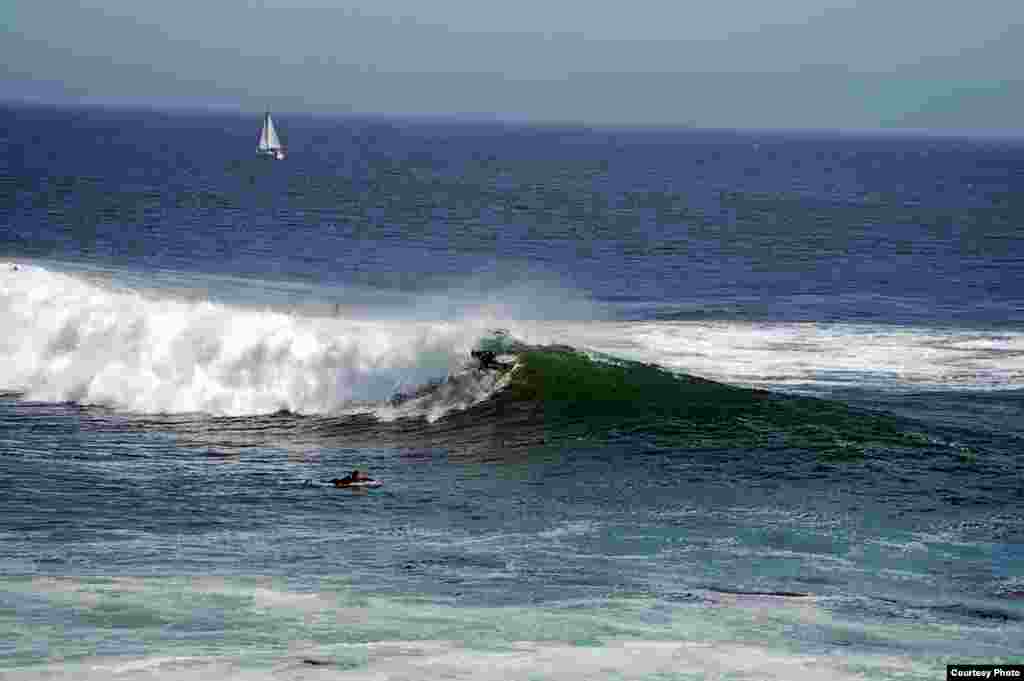 Seorang peselancar &#39;mengendarai&#39; gelombang di Santa Cruz, negara bagian California, AS (foto oleh Ly Liem / pembaca VOA)