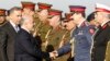 FILE - Iraqi Prime Minister Haider al-Abadi, second from left, shakes hands with military officials with Iraq Defense Minister Khaled al-Obeidi, left, during the Iraqi Army Day anniversary celebration, in Baghdad, Jan. 6, 2015. 