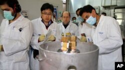 지난해 1월 이란 테흐란 인근 우라늄 농축 시설에서 국제원자력기구 IAEA 검사관들과 이란 기술자들이 농도 20%의 농축 우라늄 생산을 중단시키는 작업을 하고 있다. (자료사진)