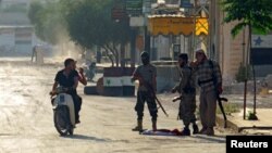 FILE - Rebel fighters from the hardline jihadist Jund al-Aqsa man a checkpoint in Taybat al-Imam town after they advanced in the town in Hama province, Syria, Aug. 31, 2016.