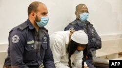 Amiram Ben Uliel, a Jewish extremist convicted of murder, reads while waiting during a sentencing hearing in Israel's central city of Lod on June 9, 2020.