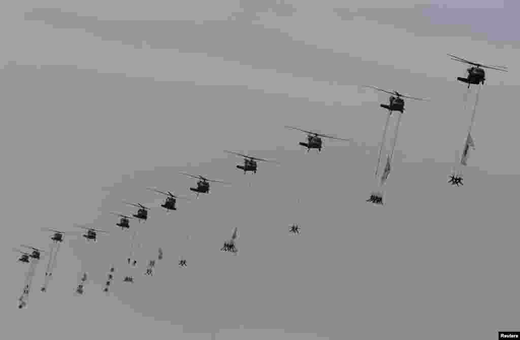 Para anggota Komando Perang Khusus digantung dari helikopter tentara dalam upacara peringatan hari jadi ke-65 pasukan bersenjata Korea Selatan di Seongnam, Seoul (1/10). 