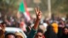 FILE - Pro-democracy protesters flash the victory sign as they take to the streets to condemn a takeover by military officials, in Khartoum, Sudan, Oct. 25, 2021. 
