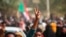 FILE - Pro-democracy protesters flash the victory sign as they take to the streets to condemn a takeover by military officials, in Khartoum, Sudan, Oct. 25, 2021. 