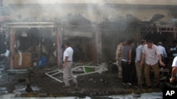 Warga setempat memeriksa lokasi sekitar meledaknya sepeda motor di dekat sebuah toko senjata di Kirkuk, 290 kilometer dari Baghdad, Irak (19/9).