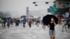 A woman wearing a mask walks past members of conservative civic groups who take part in an anti-government protest, as concerns over a fresh wave of the coronavirus disease (COVID-19) cases grow, in central Seoul, Aug. 15, 2020.